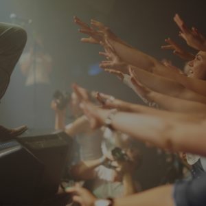 fans at a concert putting their hands in the air
